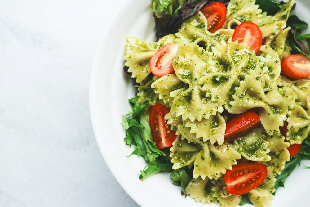 Basil pasta with tomatoes and fresh leaves