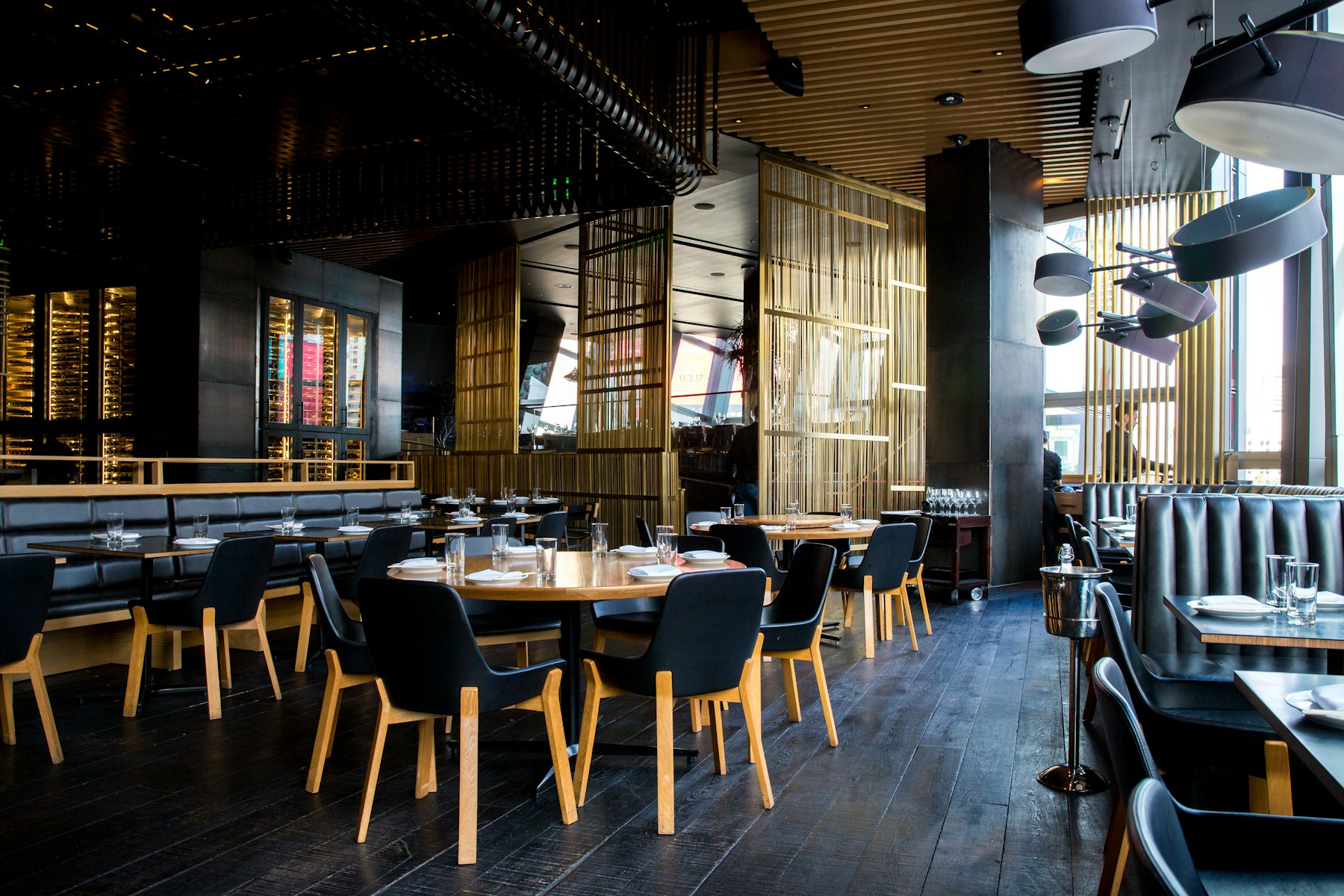 A contemporary restaurant room with warm timber and softly set tables